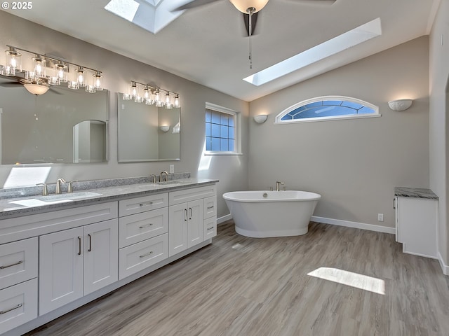 907 NW 90th St, Vancouver, WA 98665 - full bath with a skylight, double vanity, a freestanding tub, lofted ceiling, and wood finished floors
