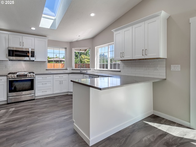 907 NW 90th St, Vancouver, WA 98665 - kitchen with appliances with stainless steel finishes, vaulted ceiling, a skylight, tasteful backsplash, and recessed lighting
