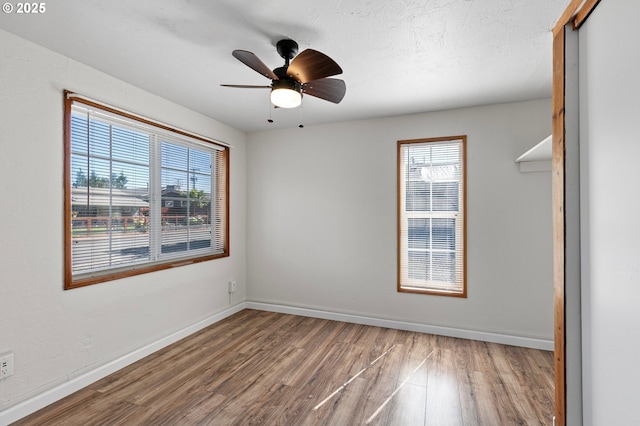 2745 C St, Springfield, OR 97477 - empty room with healthy amount of natural light, wood finished floors, baseboards, and ceiling fan