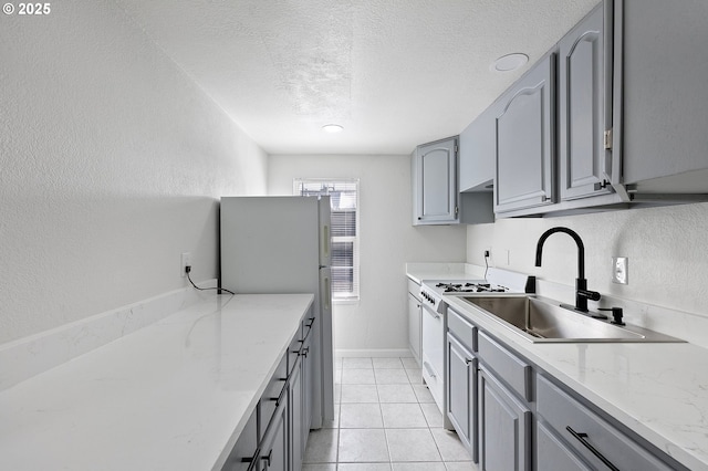 2745 C St, Springfield, OR 97477 - kitchen featuring gray cabinetry, white appliances, a sink, a textured ceiling, and a textured wall