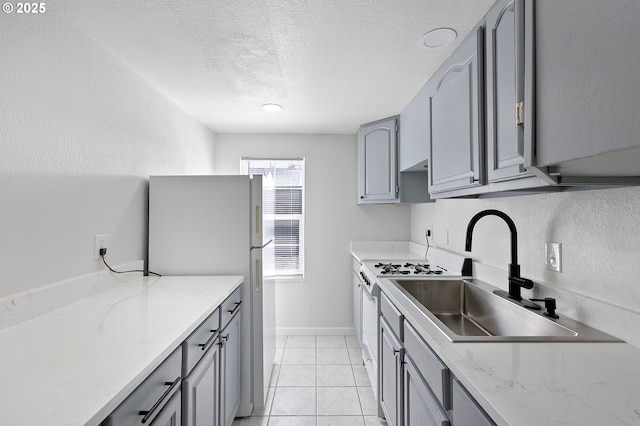 2745 C St, Springfield, OR 97477 - kitchen with gray cabinetry, a sink, white appliances, a textured ceiling, and light tile patterned flooring