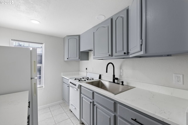 2745 C St, Springfield, OR 97477 - kitchen with gray cabinets, white appliances, a sink, a textured ceiling, and baseboards
