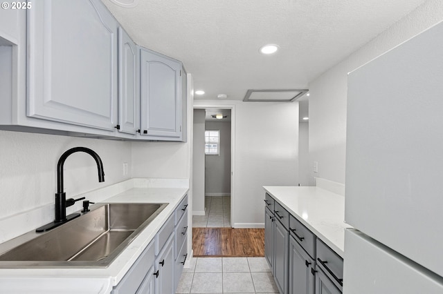 2745 C St, Springfield, OR 97477 - kitchen with a sink, freestanding refrigerator, gray cabinets, light tile patterned floors, and recessed lighting