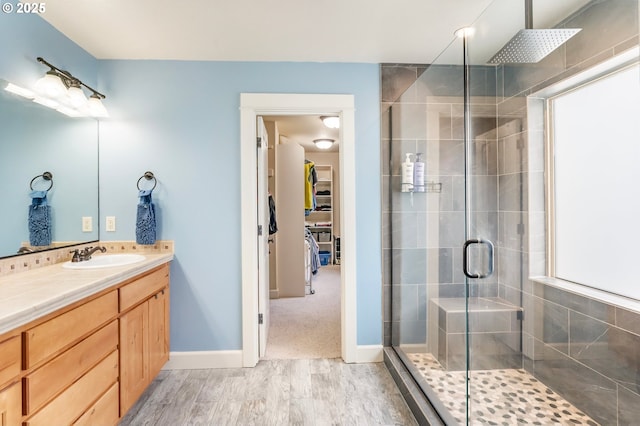 14390 SW Connor Pl, Portland, OR 97224 - full bathroom featuring a stall shower, vanity, a walk in closet, and wood finished floors