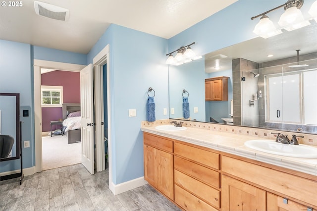 14390 SW Connor Pl, Portland, OR 97224 - ensuite bathroom featuring a stall shower, double vanity, and wood finished floors