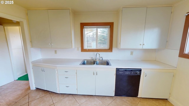 kitchen with sink, light tile patterned floors, white cabinets, and black dishwasher