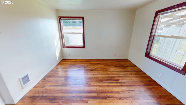 unfurnished room featuring hardwood / wood-style flooring and crown molding