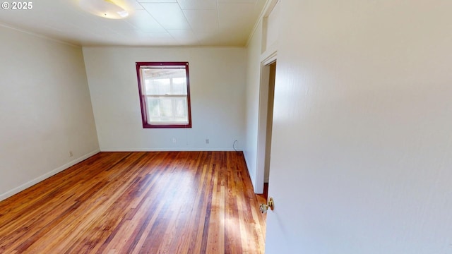 unfurnished room featuring hardwood / wood-style flooring and crown molding