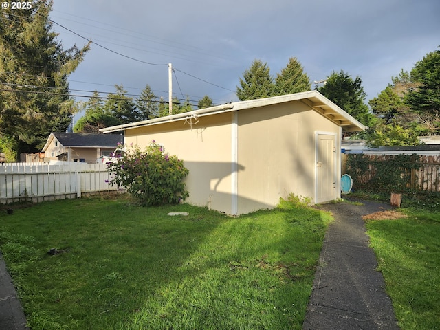 view of home's exterior featuring an outdoor structure and a yard