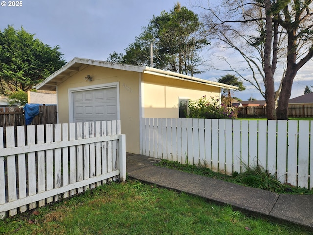 view of yard featuring a garage and an outbuilding