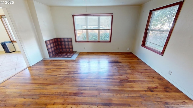 spare room featuring wood-type flooring and crown molding