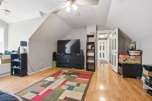 18522 SW Mcclarey Dr, Beaverton, OR 97007 - bedroom with light wood finished floors, lofted ceiling, a textured ceiling, baseboards, and a ceiling fan