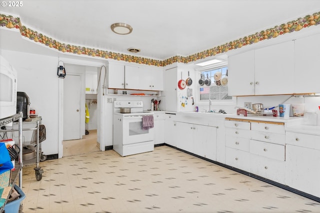 kitchen featuring white cabinetry, sink, and electric range