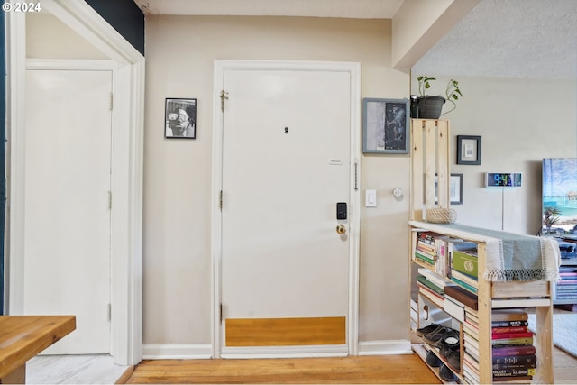 entrance foyer featuring light wood finished floors and baseboards