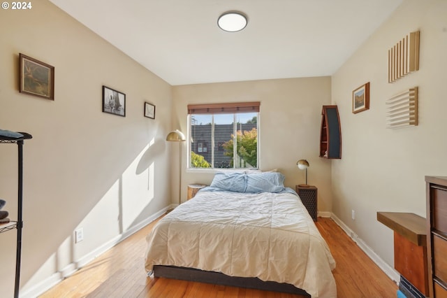 bedroom with wood finished floors and baseboards