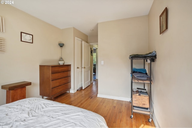 bedroom featuring light wood-style floors and baseboards