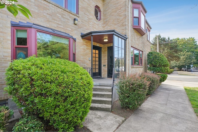 entrance to property featuring brick siding