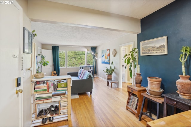 living area with a textured ceiling, wood finished floors, and baseboards
