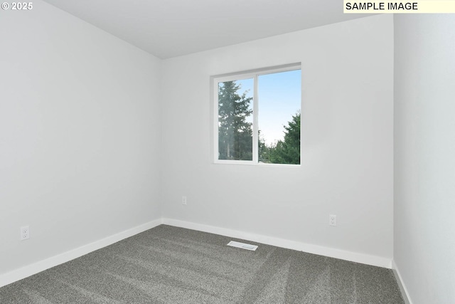 spare room with visible vents, dark carpet, and baseboards