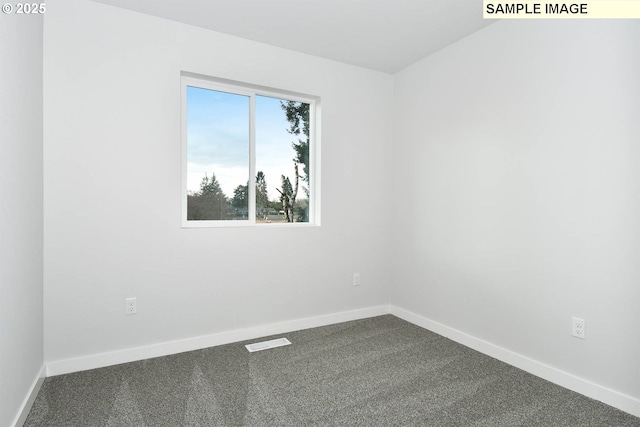 empty room featuring dark colored carpet, visible vents, and baseboards