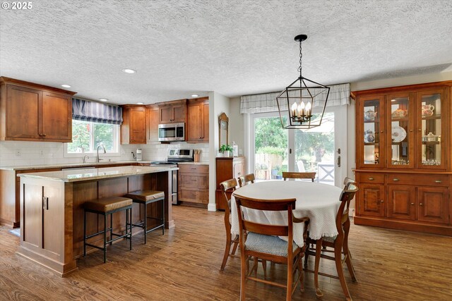 2648 SE Risley Ave, Milwaukie, OR 97267 - dining area featuring a chandelier, wood finished floors, a textured ceiling, and recessed lighting