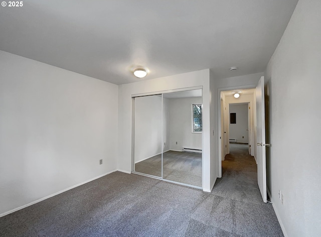 unfurnished bedroom featuring a closet, baseboards, carpet flooring, and a baseboard heating unit