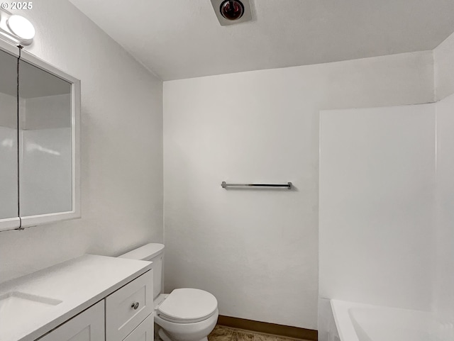 full bath featuring toilet, a bath, vanity, and baseboards