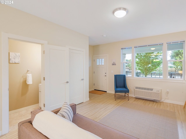 living area with light hardwood / wood-style flooring and an AC wall unit