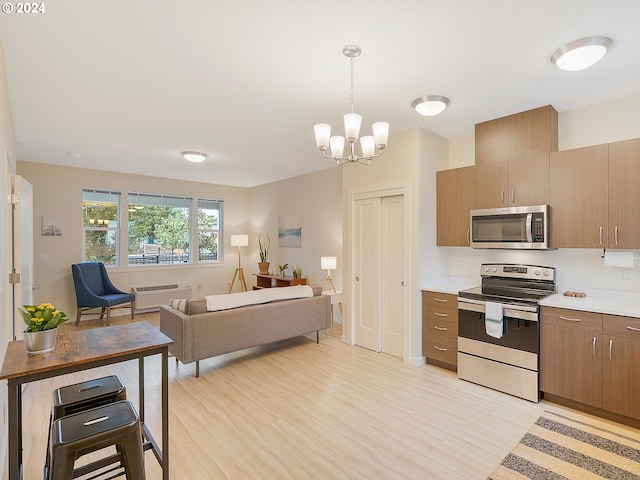 10827 E Burnside St, Portland, OR 97035 - kitchen with stainless steel appliances, light countertops, open floor plan, and light wood finished floors