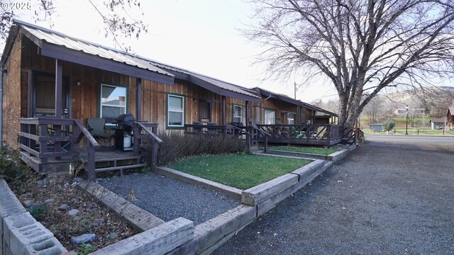 145 E Franklin Ave, Dayville, OR 97825 - view of side of home with a metal roof, board and batten siding, covered porch, and a lawn