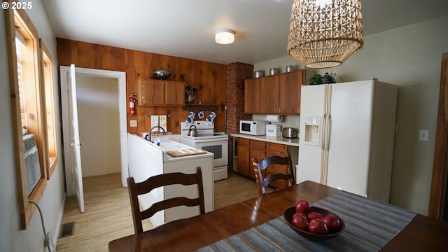 145 E Franklin Ave, Dayville, OR 97825 - kitchen with white appliances, light wood-type flooring, light countertops, and brown cabinetry