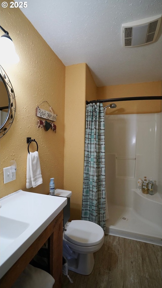 145 E Franklin Ave, Dayville, OR 97825 - bathroom with wood finished floors, a textured wall, curtained shower, and vanity