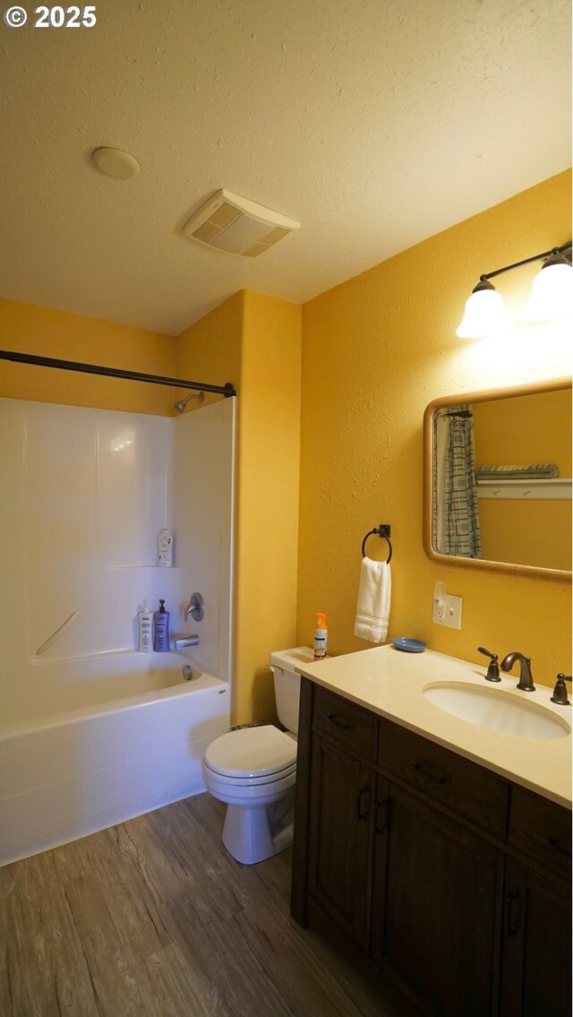 145 E Franklin Ave, Dayville, OR 97825 - bathroom featuring wood finished floors, vanity, shower / bath combination, a textured ceiling, and a textured wall