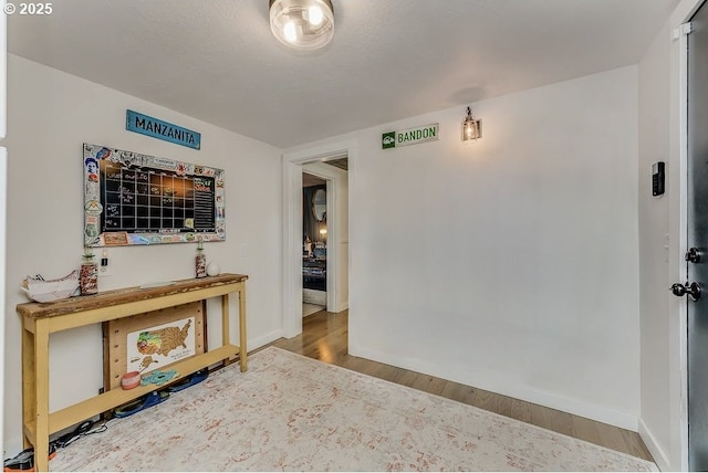 hallway featuring hardwood / wood-style flooring and a textured ceiling