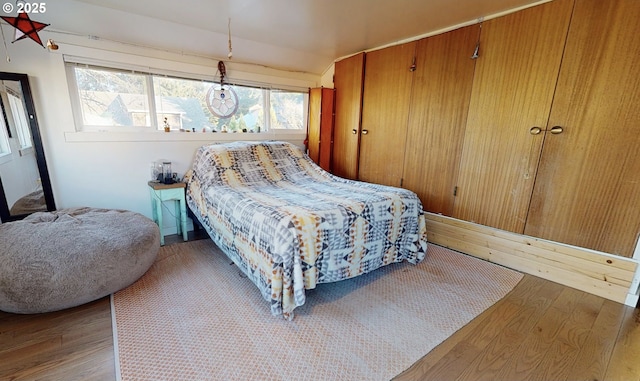 bedroom with lofted ceiling and wood-type flooring