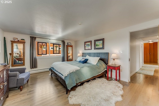 bedroom featuring a baseboard radiator and light hardwood / wood-style flooring