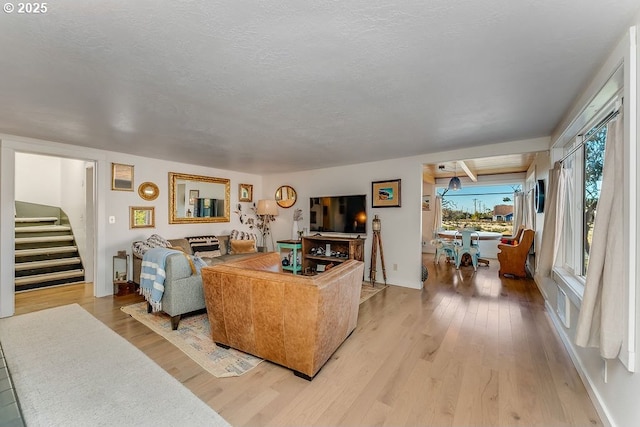 living room featuring light hardwood / wood-style flooring and a textured ceiling