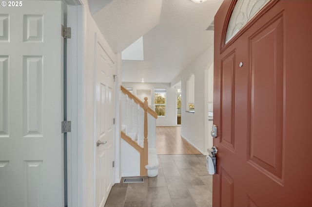 foyer entrance featuring stairway and visible vents