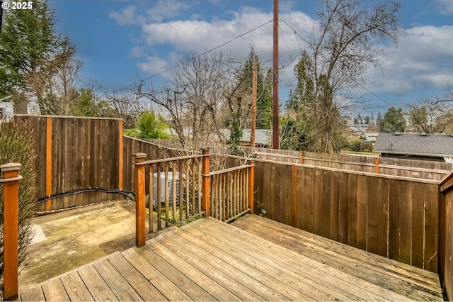 wooden terrace with a fenced backyard