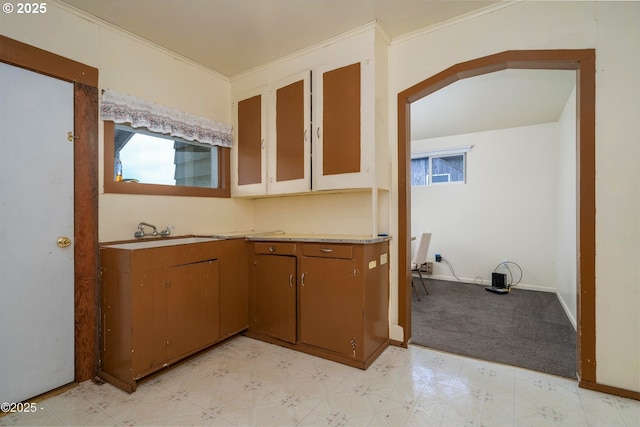 118 SW Brook St, Newport, OR 97365 - kitchen with light floors, light countertops, baseboards, brown cabinetry, and crown molding