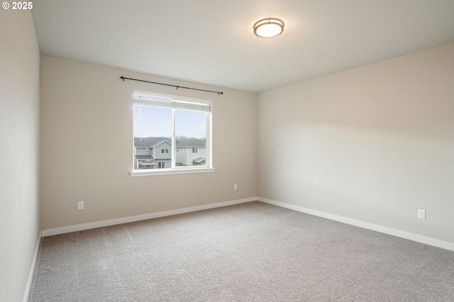 empty room featuring baseboards and carpet flooring