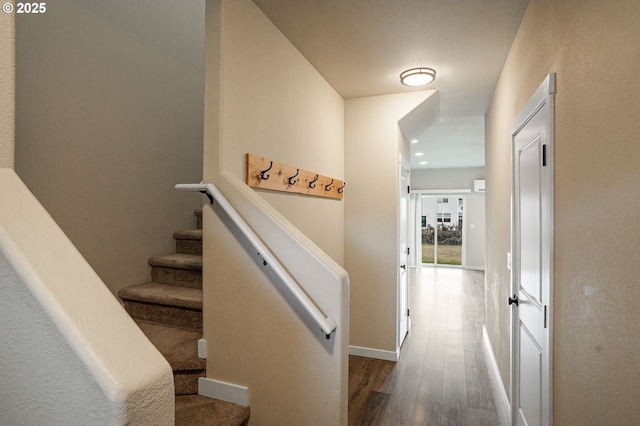 stairway featuring recessed lighting, wood finished floors, and baseboards