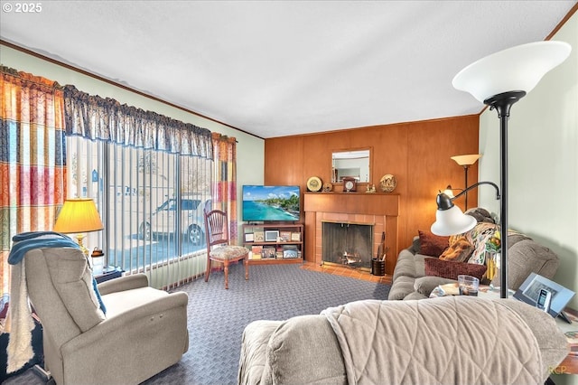 carpeted living room featuring wooden walls and a fireplace with flush hearth