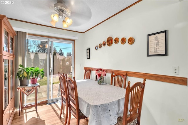 dining area featuring a ceiling fan, crown molding, and wood finished floors