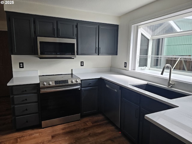 5740 SE Golden Rd, Hillsboro, OR 97123 - kitchen featuring stainless steel appliances, a sink, dark wood-style flooring, and light countertops