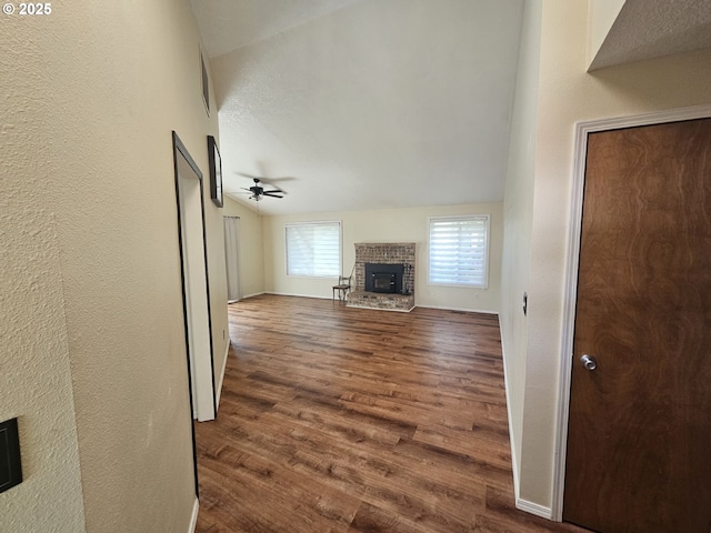 5740 SE Golden Rd, Hillsboro, OR 97123 - unfurnished living room with a brick fireplace, a ceiling fan, dark wood finished floors, baseboards, and lofted ceiling