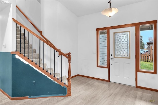 foyer featuring stairs, wood finished floors, and baseboards