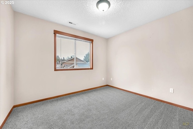 carpeted spare room with visible vents, a textured ceiling, and baseboards