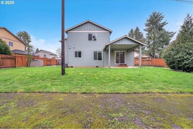 back of house with board and batten siding, crawl space, a fenced backyard, and a yard