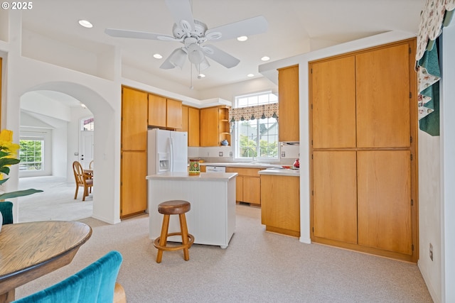 1939 NE Harewood Pl, Hillsboro, OR 97124 - kitchen featuring open shelves, white fridge with ice dispenser, arched walkways, light carpet, and a center island